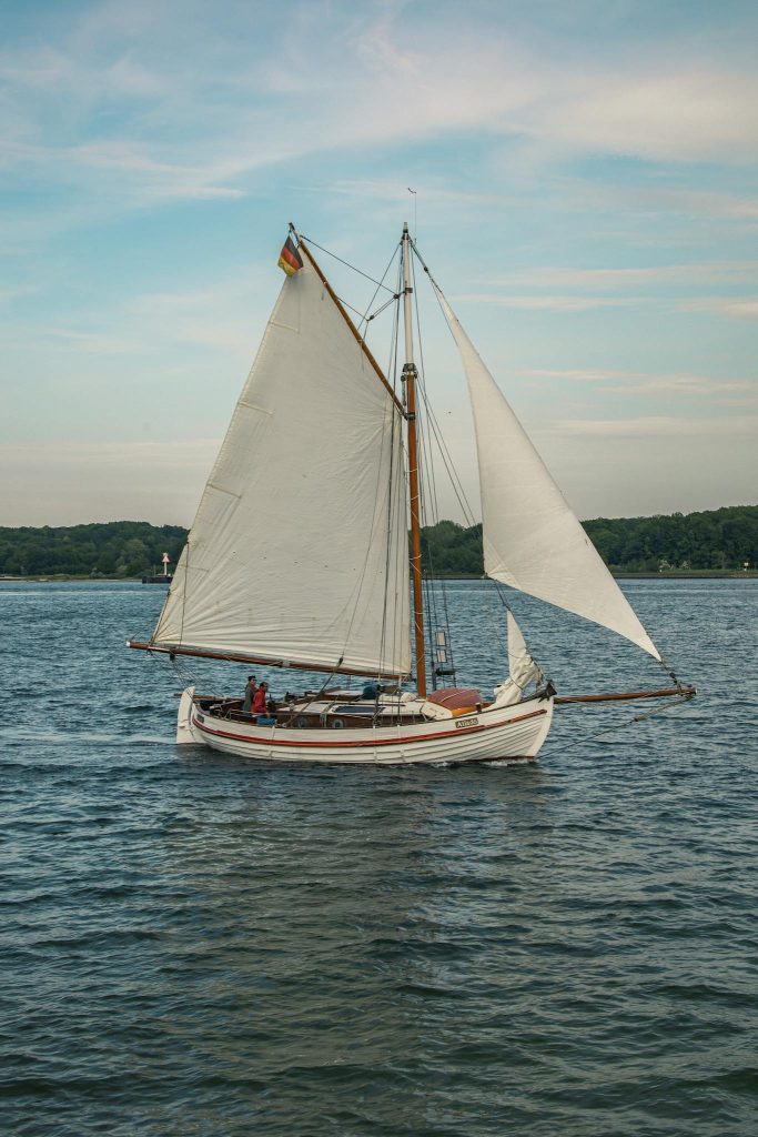 Vintage sailboat cruising on calm waters near Kiel, Germany, perfect for travel and maritime themes.